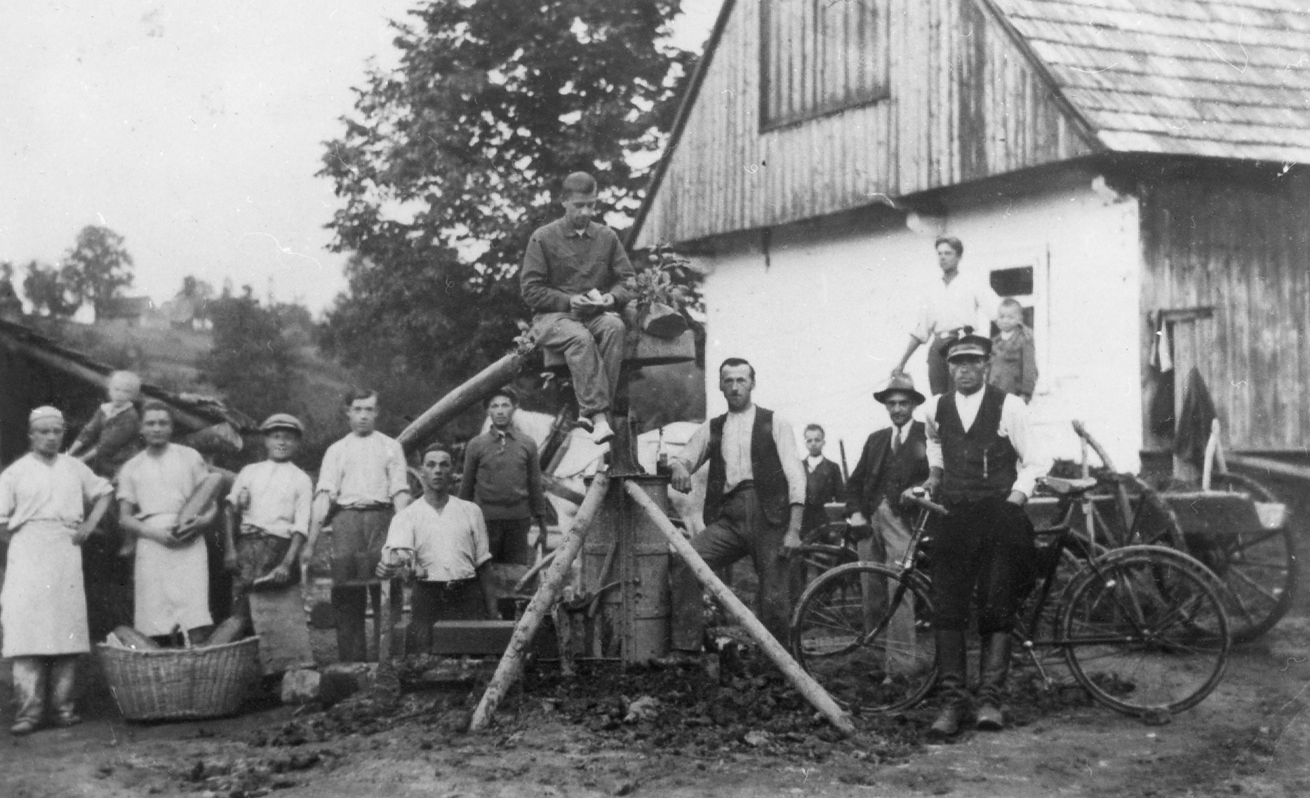 Rok i miejsce wykonania: 1934 r., Łętownia, gm. Jordanów, pow. suski, woj. małopolskie.

Fotografia przedstawia kilkunastu mężczyzn przy pracy. Stoją wokół urządzenia do robienia odwiertów, trzymając w dłoniach różne, trudne do rozpoznania przedmiotu. Wśród nich są chłopcy – trzech młodszych oraz jeden starszy. W tle widać wiejskie domy, a po prawej stronie – duży budynek gospodarczy. Z napisu na odwrocie wynika, że jest to „cegielnia”, należąca do rolnika we wsi Łętownia k. Jordanowa.

Autor zdjęcia: nieznany.

Zdjęcie ze zbiorów prywatnych, nadesłał: Emil Biela z Myślenic, pow. myślenicki, woj. małopolskie.

Nr kat. 33-1