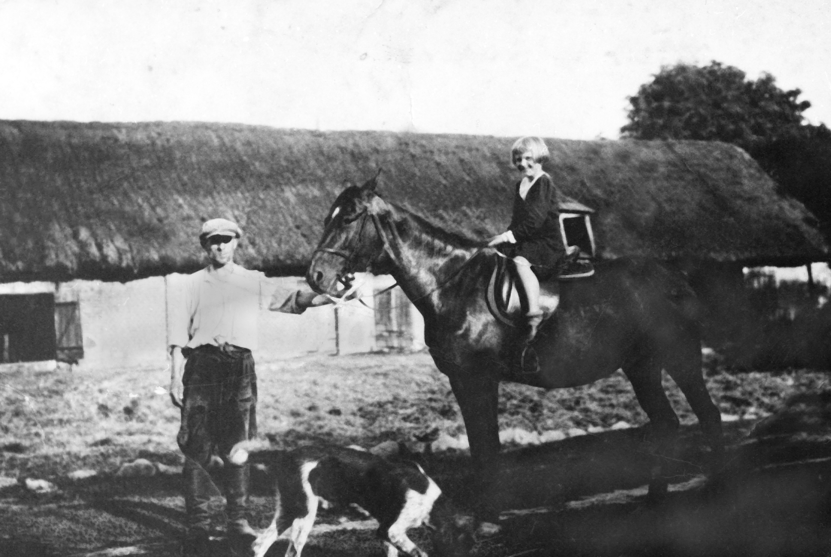 Rok i miejsce wykonania: brak danych.

Fotografia przedstawia mężczyznę trzymającego za uzdę konia, na którym siedzi jasnowłosa dziewczynka. Koło nich biega czarno-biały pies. Dziewczynka ma krótko ścięte włosy („na pazia”), jest w ciemnej sukience z białym kołnierzykiem, na stopach ma skarpetki i buty. Mężczyzna jest w codziennym stroju: jasnej koszuli z podwiniętymi rękawami, spodniach wpuszczonych w wysokie buty i w kaszkiecie. W tle widać niskie zabudowania gospodarcze kryte strzechą.

Według informacji darczyńcy fotografia przedstawia F. Pichera przy chlewni, z koniem, na którym siedzi jego najstarsza córka Lucyna.

Autor zdjęcia: nieznany.

Zdjęcie ze zbiorów prywatnych, nadesłał: Sławomir Picher z Białej, pow. kaliski, woj. wielkopolskie.

Nr kat. 48-12