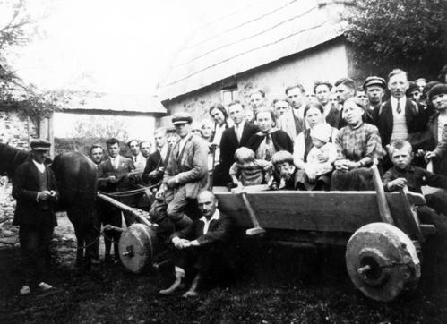 Rok i miejsce wykonania: 15.01.1940 r., Chrustowo, gm. Oborniki, pow. obornicki, woj. wielkopolskie.

Fotografia przedstawia kilkanaście osób, głównie kobiet, siedzących dookoła stołu podczas skubania pierza. Na pierwszym planie widoczna jest około siedmioletnia dziewczynka, która również bierze udział w zwyczajowym skubaniu pierza. W pomieszczeniu znajduje się także dwóch mężczyzn. Jeden z nich, w cylindrze, stoi za siedzącymi, a drugi siedzi między kobietami. W tle widoczne regały z naczyniami kuchennymi i zastawą stołową oraz słoje z przetworami.

Z tyłu zdjęcia napis: „15.01.1940 rok – data wykonania. Przedstawia ludność wiejską, utrwala posiłek zwany „pępkiem” podczas darcia pierza, wykonane przez Ludwika Krakowiaka, wieś Chrustowo” (pisownia oryginalna)

Autor zdjęcia: Ludwik Krakowiak.

Nr kat. 58-5