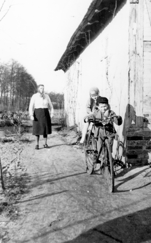 Rok i miejsce wykonania: 1943 r., przedmieścia Wolsztyna, gm. Wolsztyn, pow. wolsztyński, woj. wielkopolskie.

Fotografia przedstawia dwójkę dzieci pozujących przy rowerze. Jednoślad jest duży, dla dorosłych, kierownicę trzyma chłopiec,a za nim siedzi młodsza, kilkuletnia dziewczynka. Kilka metrów za nimi stoi kobieta w chuście, białej bluzce i ciemnej spódnicy. W tle widać drewniany budynek i podwórko. Z informacji nadesłanych przez nadawczynię zdjęcia wynika, że przedstawia ono jej babcię, Zofię I., z dziećmi (czyli z mamą i wujkiem nadawczyni – Marią oraz Tadeuszem, siedzącymi na rowerze). Dołącza ona również wyjaśnienie: „Na zdjęciu nie ma dziadka, gdyż w tym czasie został wywieziony na przymusowe roboty do Niemiec. Fotografię wykonano na przedmieściach Wolsztyna podczas wojny”.

Autor zdjęcia: nieznany.

Zdjęcie ze zbiorów prywatnych, nadesłała: Larysa Wach z Wolsztyna, pow. wolsztyński, woj. wielkopolskie.

Nr kat. 132-4