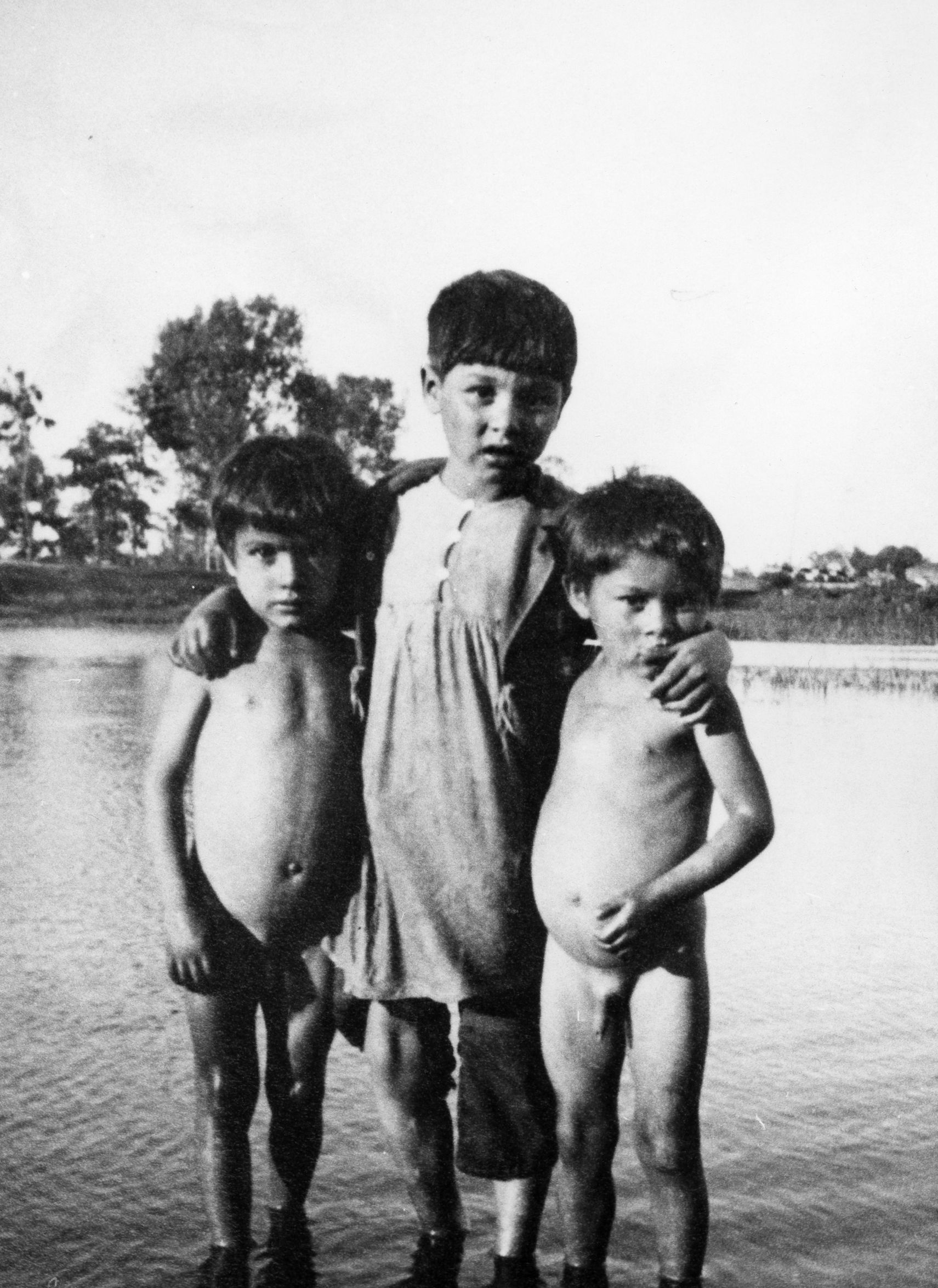 Rok i miejsce wykonania: lato 1936 r., okolice Łowicza, pow. łowicki, woj. łódzkie.

Fotografia przedstawia dwóch nagich chłopców, około pięcioletnich, oraz stojącego między nimi i obejmującego ich ramionami starszego chłopca w koszuli do kolan. Dzieci stoją nad rzeką, na której przeciwległym brzegu widać zabudowania wiejskie. Na odwrocie zdjęcia napis: „Dzieci wiejskie”.

Autor zdjęcia: Ryszard Bratkowski, ojciec nadawcy.

Zdjęcie ze zbiorów prywatnych, nadesłał: Jerzy Bratkowski z Łodzi, woj. łódzkie.

Nr kat. 307-1