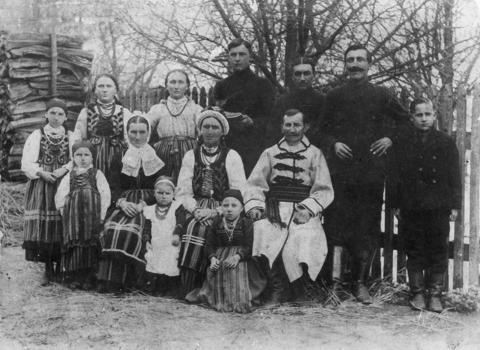 Rok i miejsce wykonania: 1918 r., Zawada k. Tomaszowa Mazowieckiego, gm. Tomaszów Mazowiecki, pow. tomaszowski, woj. łódzkie.

Fotografia przedstawia liczną rodzinę nadawcy ze wsi Zawady, ubraną w regionalne stroje ludowe. Zdjęcie wykonano na podwórku ich domostwa. Od prawej stoją: Józef R., Stanisław R., Franciszek R., Antoni R., Józefa R., Zofia R., Stefania R, natomiast siedzą od prawej: Wincenty i Marianna R. oraz Julia L. z dziećmi, od lewej: Zofia, Stanisława i Antonina.

Autor zdjęcia: nieznany.

Zdjęcie ze zbiorów prywatnych, nadesłał: Sławomir Ruta z Zawady k. Tomaszowa Mazowieckiego, pow. tomaszowski, woj. łódzkie.

Nr kat. 76-1